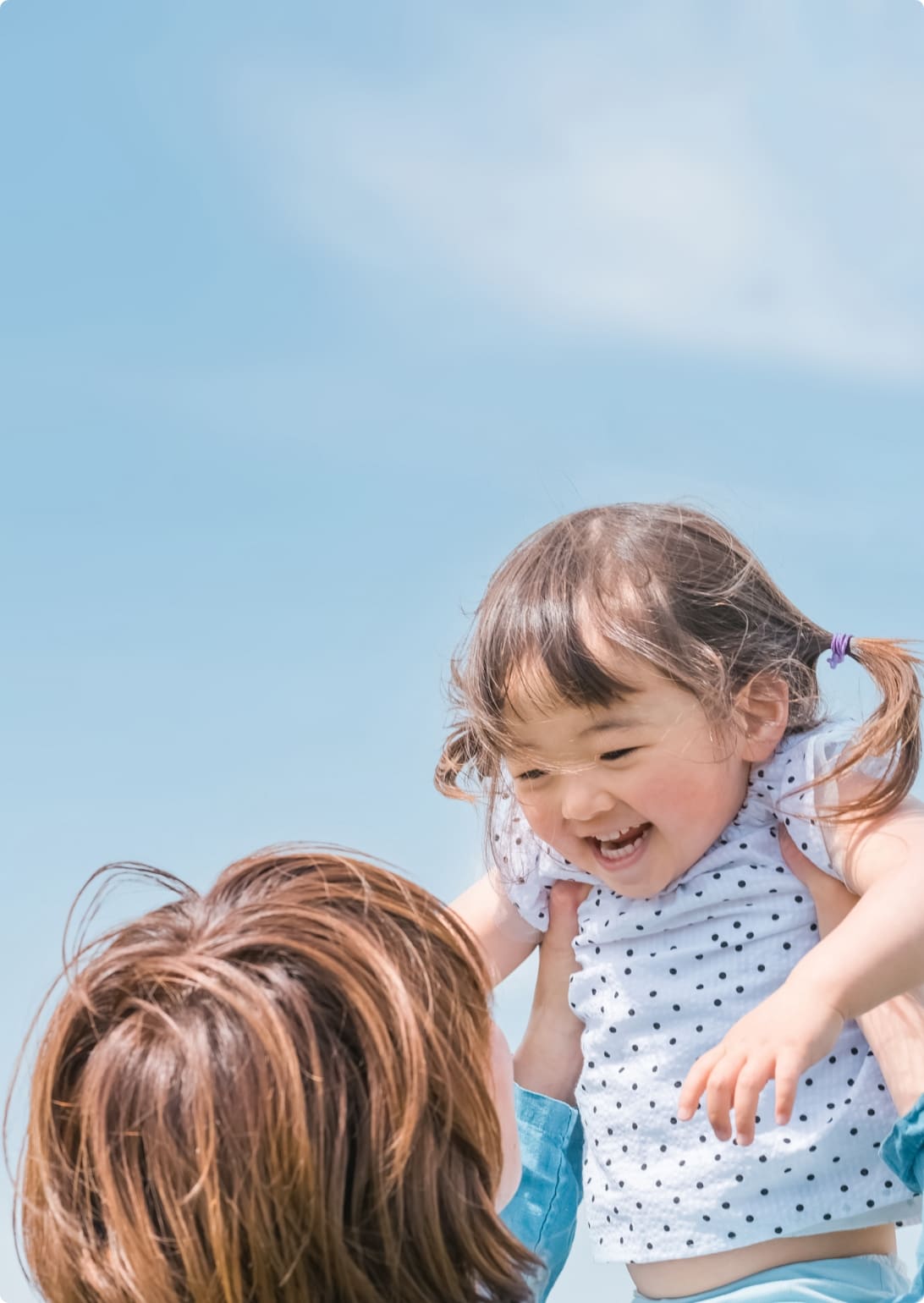 子どもを持ち上げる保護者