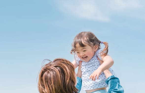 子どもを持ち上げる保護者